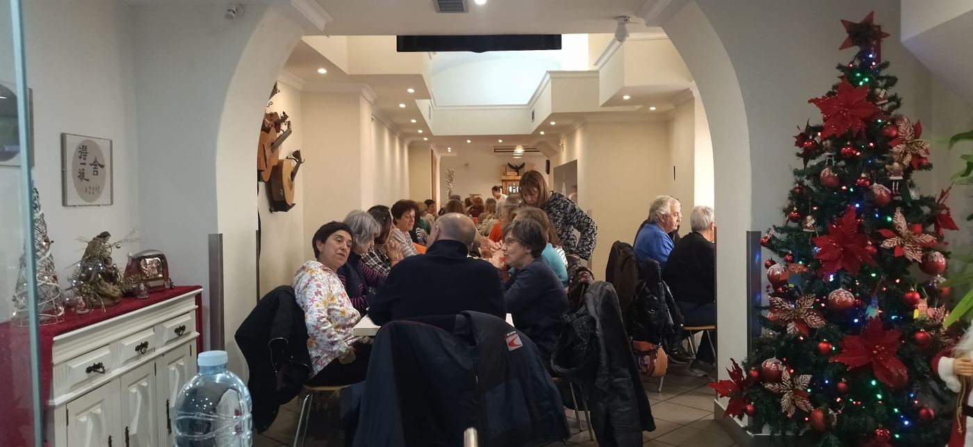 A sala cheia num almoço de Natal, com a árvore enfeitada ao fundo