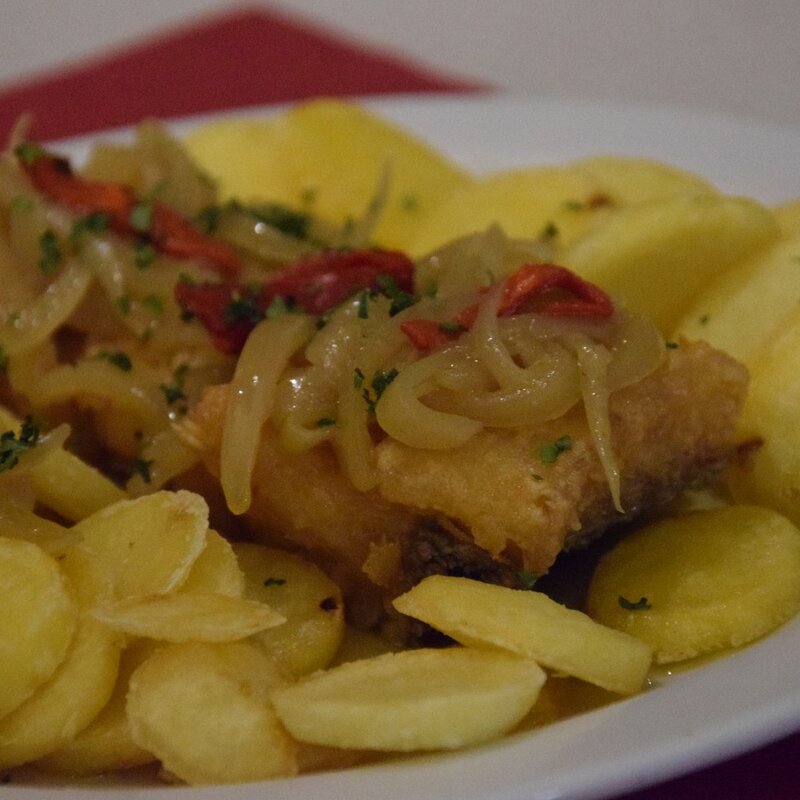 Posta de bacalhau frita com cebolada, pimento vermelho e batata às rodelas