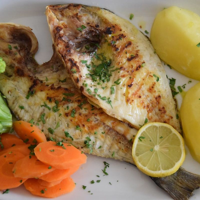 Dourada grelhada com batata cozida, cenoura, brócolos e limão