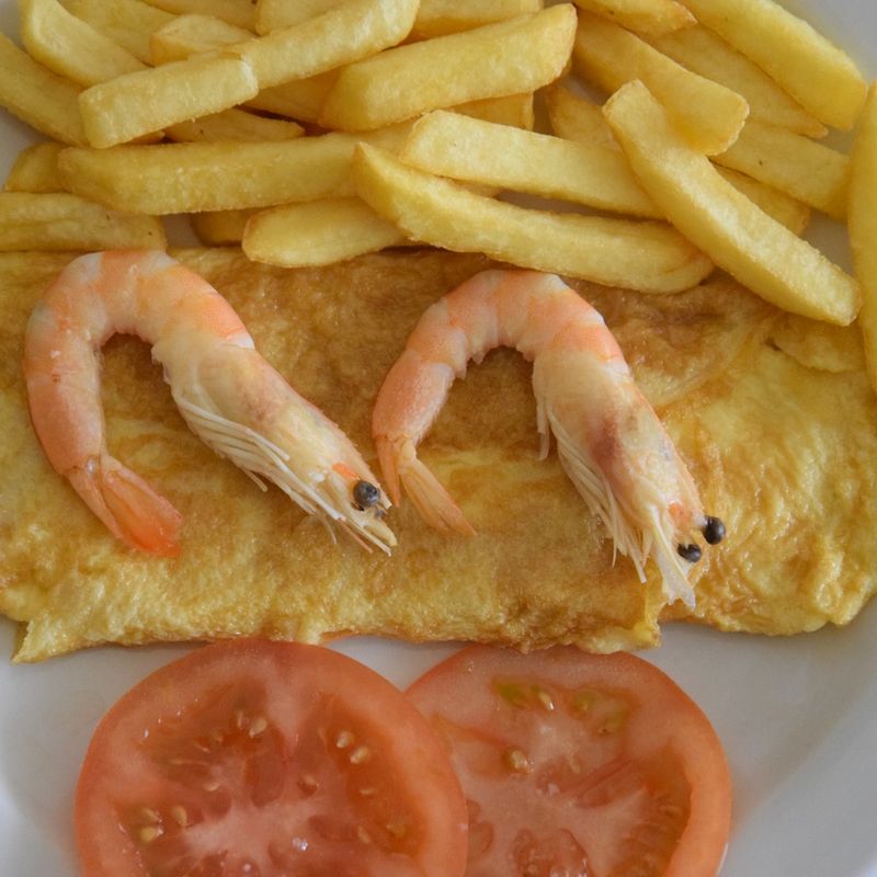 Omelete com camarão, batata frita e rodelas de tomate