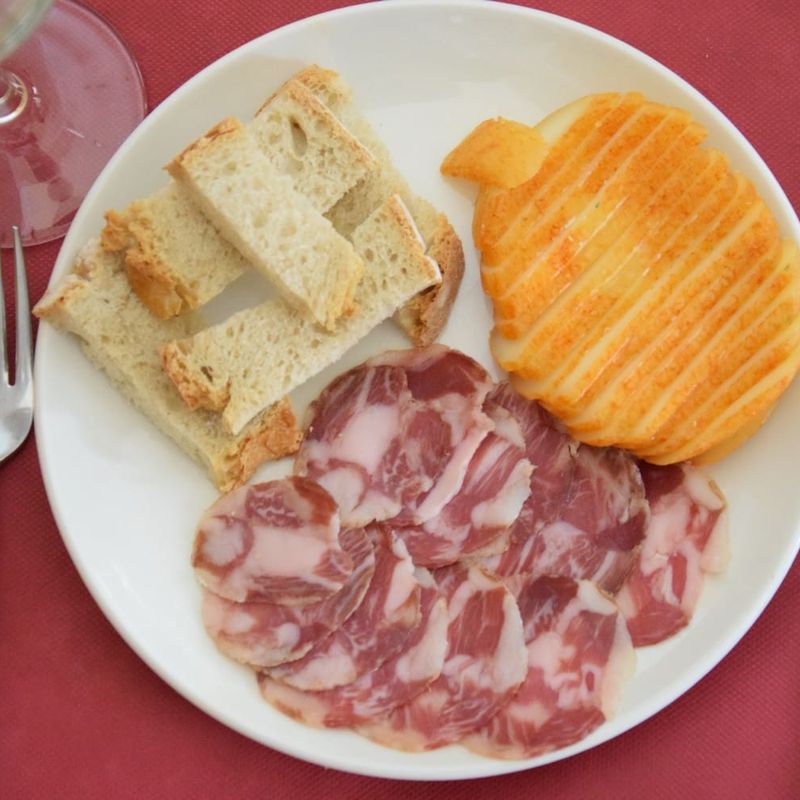 Presunto fatiado, queijo regional e pão torrado num prato