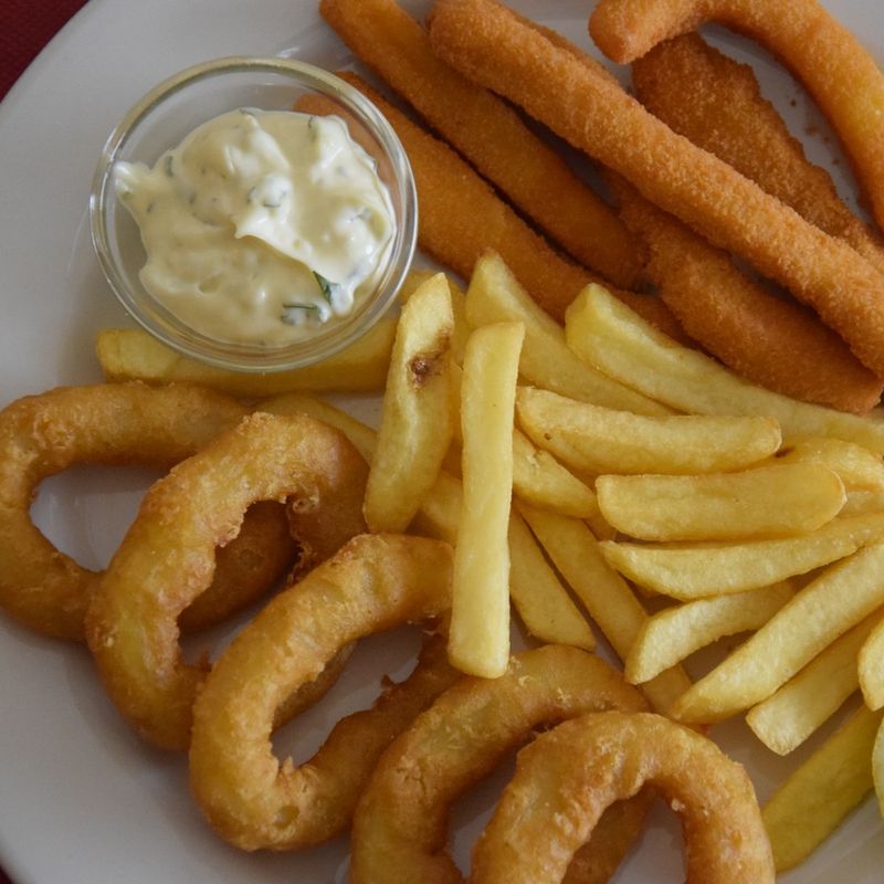Tiras de choco e argolas fritas com batata frita, maionese e limão