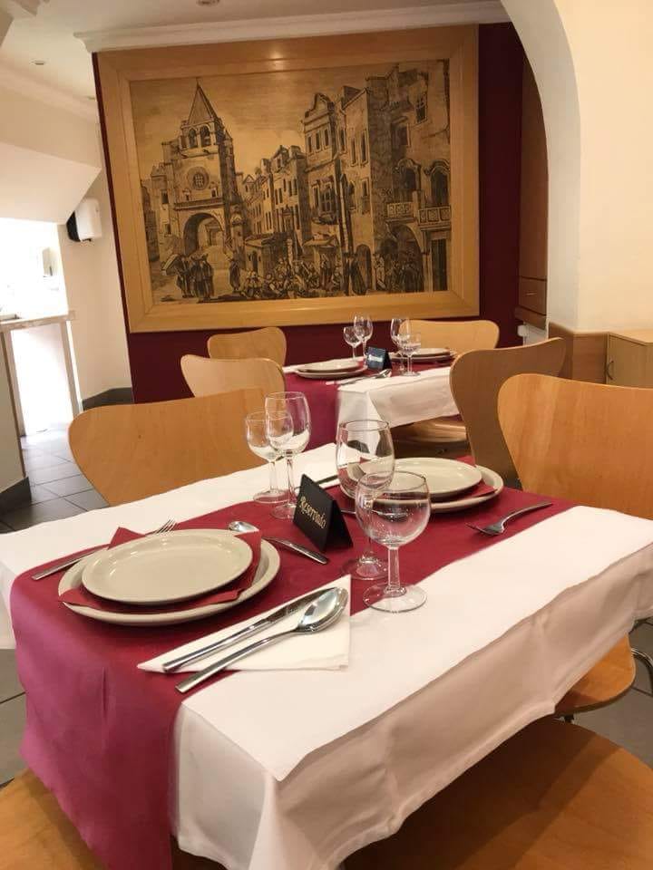 Uma mesa posta e reservada, com copos e guardanapos grenás