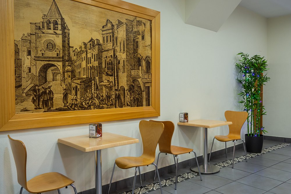 A sala com a grande gravura emoldurada da antiga Sé e da praça